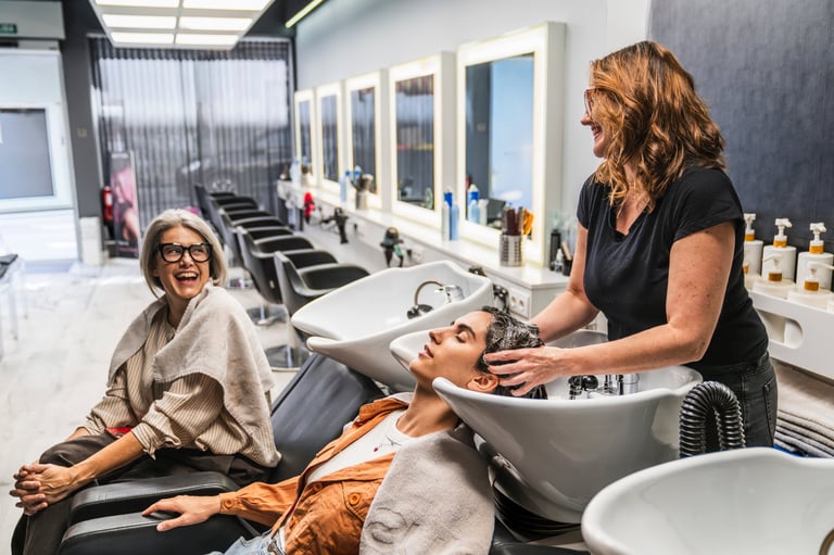 Stylist washing a client's hair in a salon